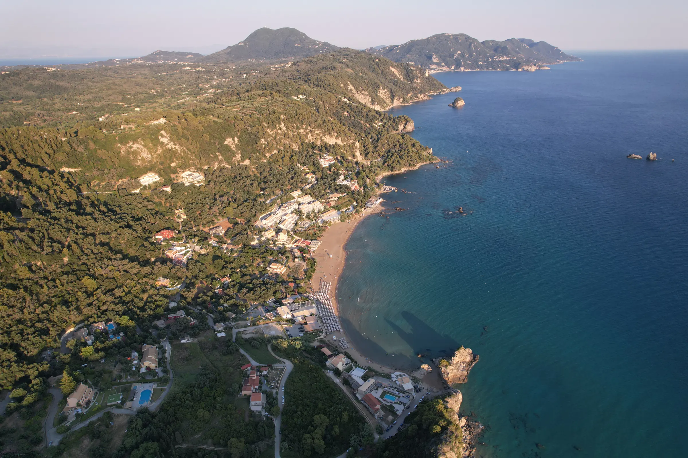Η δυτική ακτή της Κέρκυρας από ψηλά, με πράσινους λόφους πάνω από τη θάλασσα